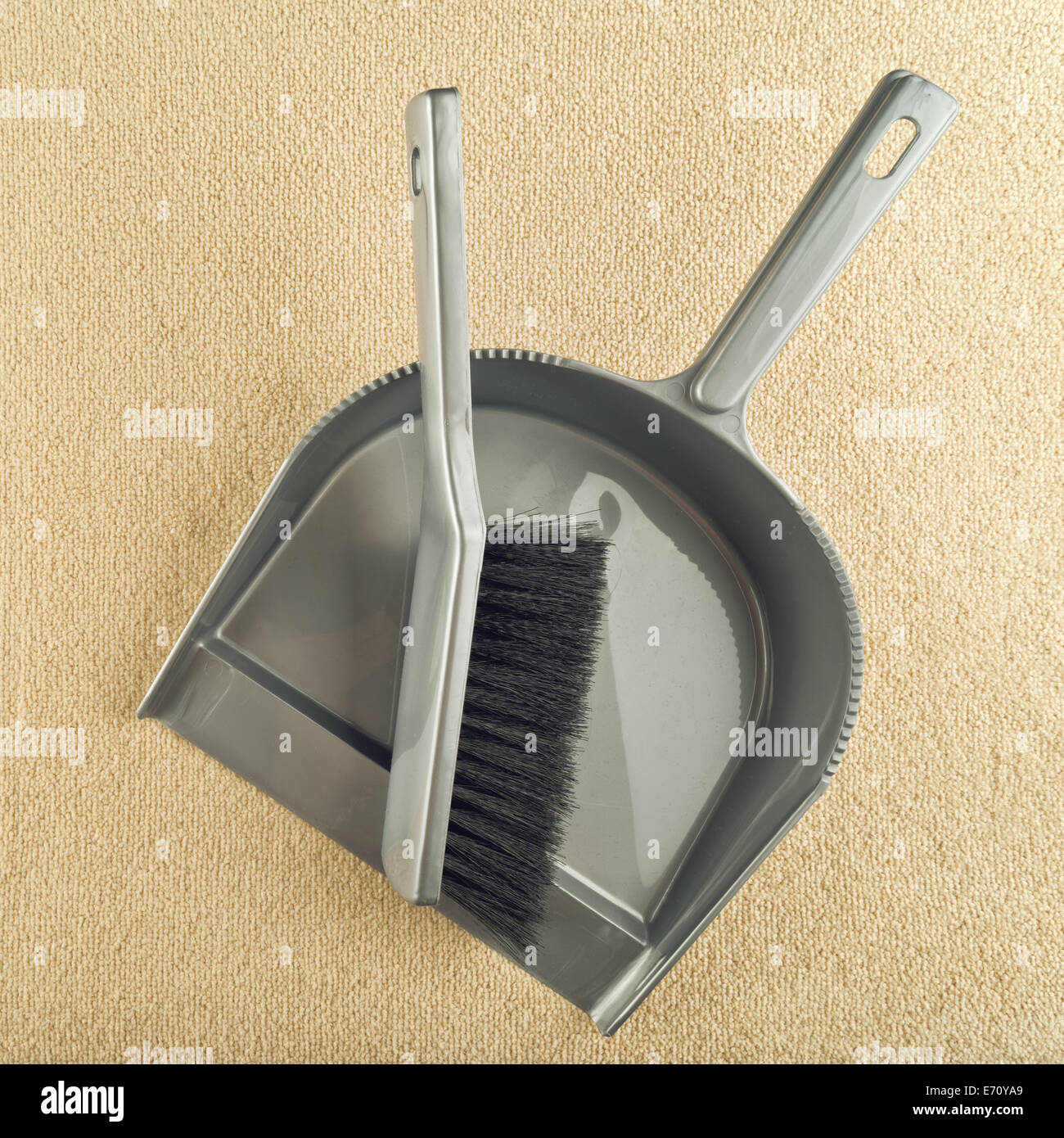 Dustpan and brush floor sweeper on carpet floor. House cleaning work
