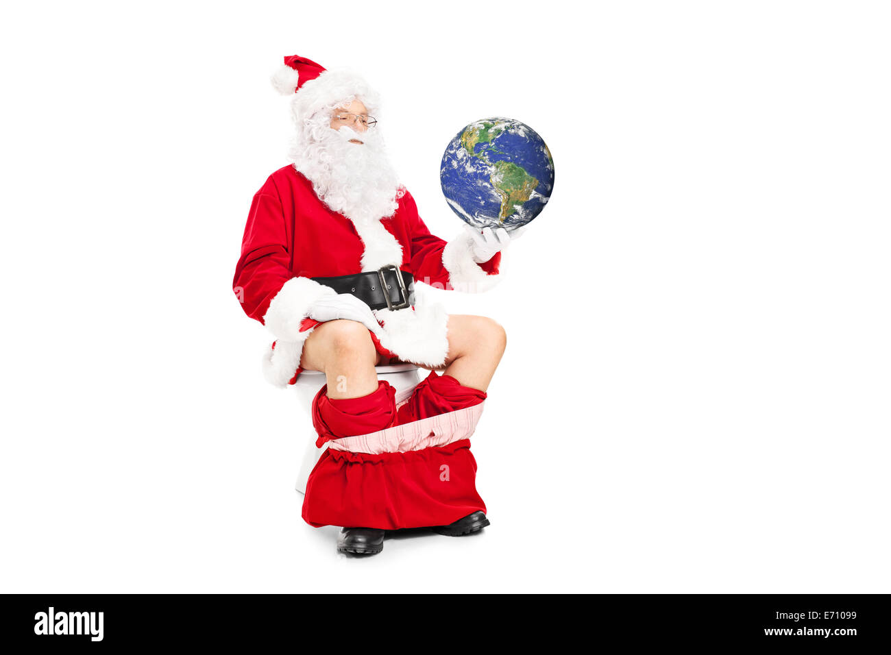 Santa holding the planet in hand seated on toilet isolated on white background Stock Photo