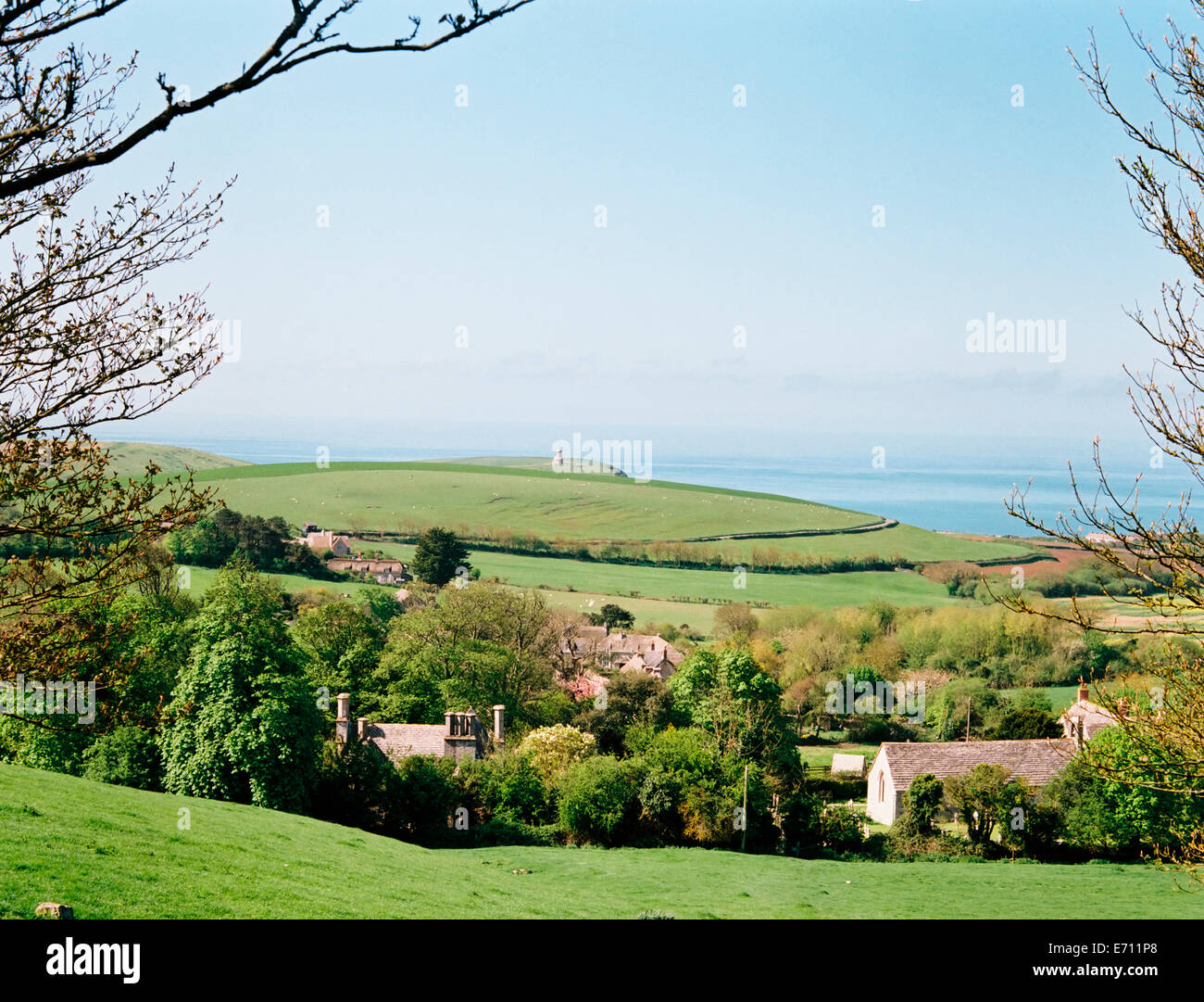 View from a hilltop over a village in the valley, looking out to sea from the coast. Stock Photo