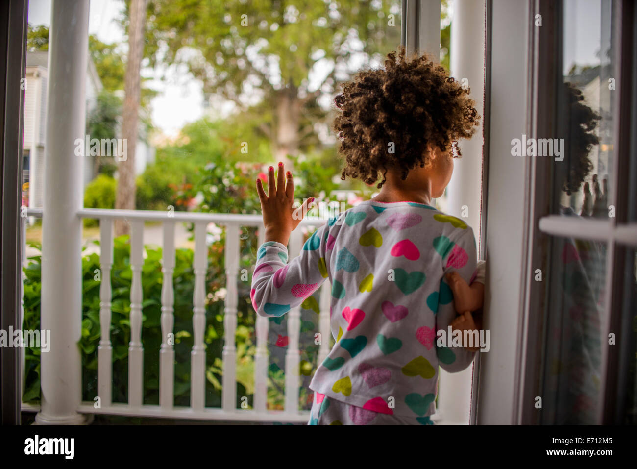 Rear view of girl sliding open patio door Stock Photo