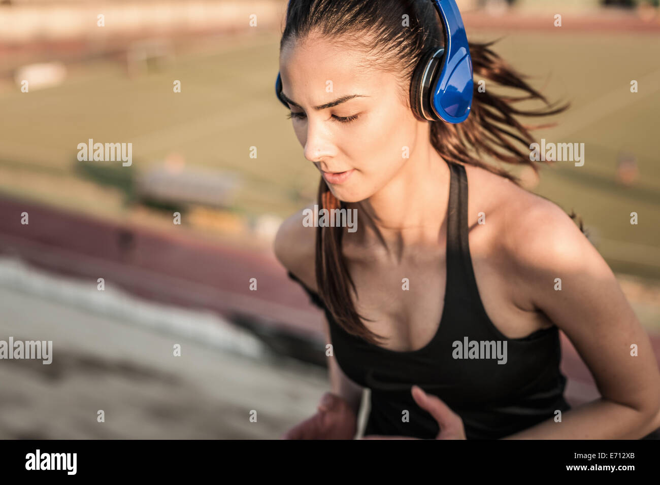 Young woman wearing headphones running Stock Photo