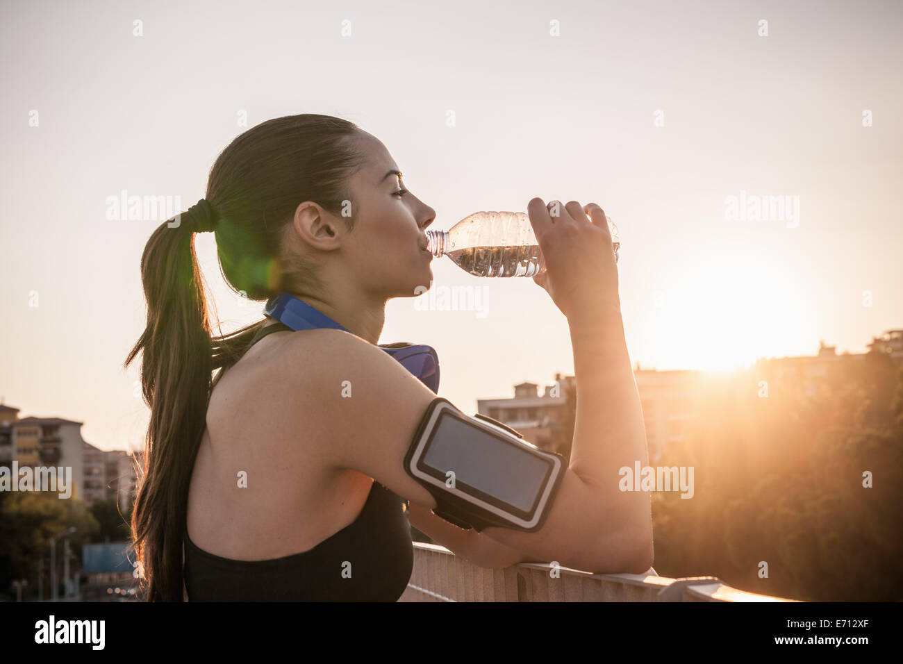 Young woman wearing armband drinking water Stock Photo