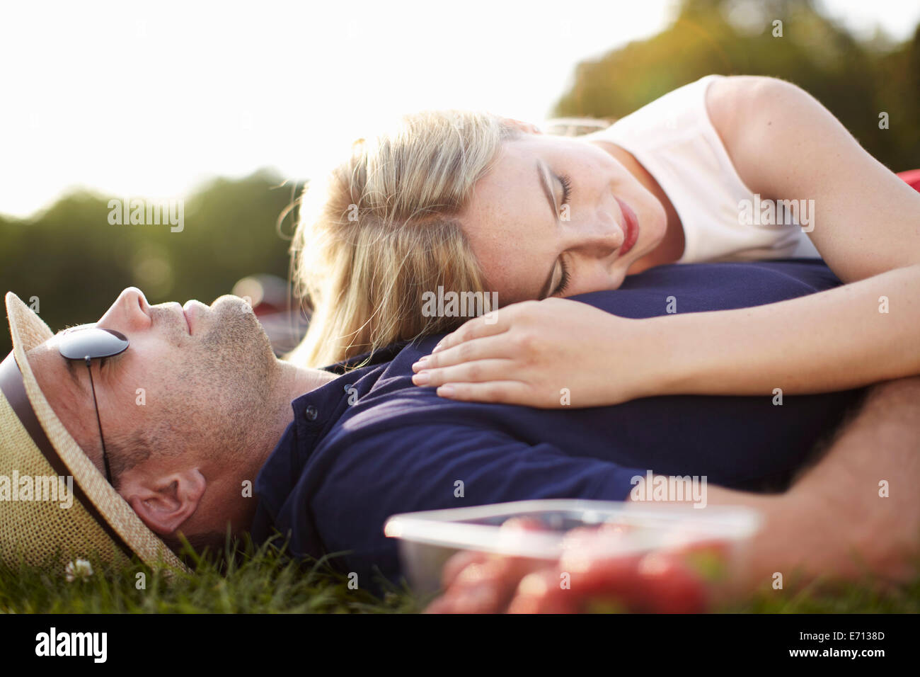 Couple lying asleep in park Stock Photo