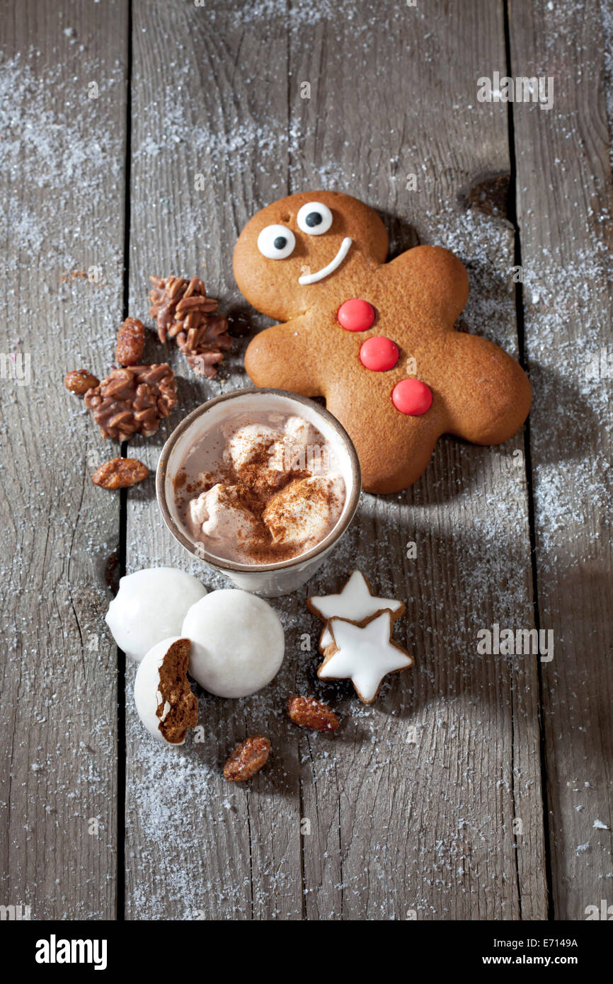 Gingerbread man, Christmas cookies and a mug of cocoa with cream on grey wood Stock Photo