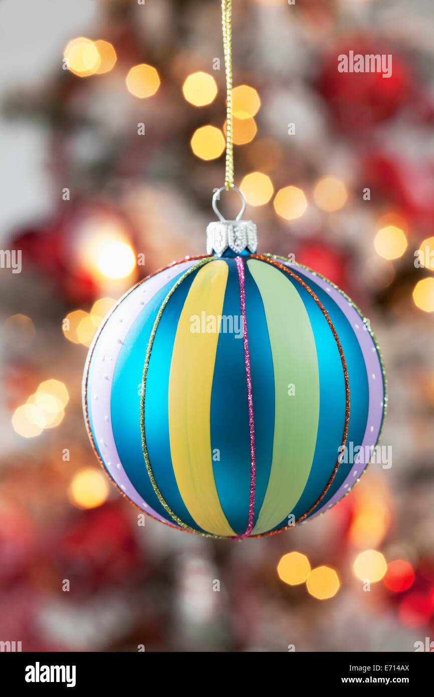 Christmas bauble hanging in front of blurred flares Stock Photo