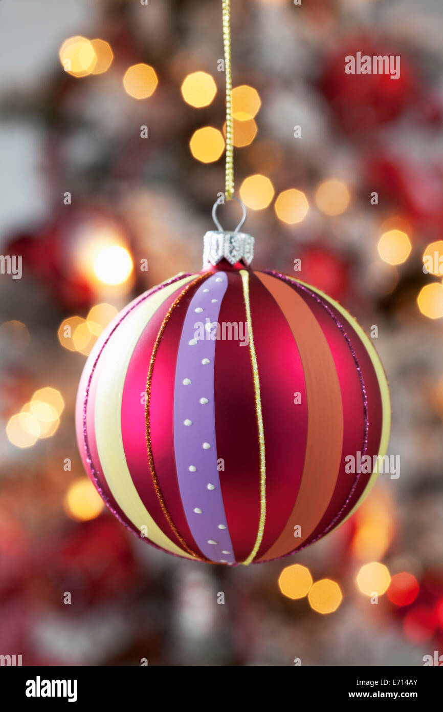 Christmas bauble hanging in front of blurred flares Stock Photo