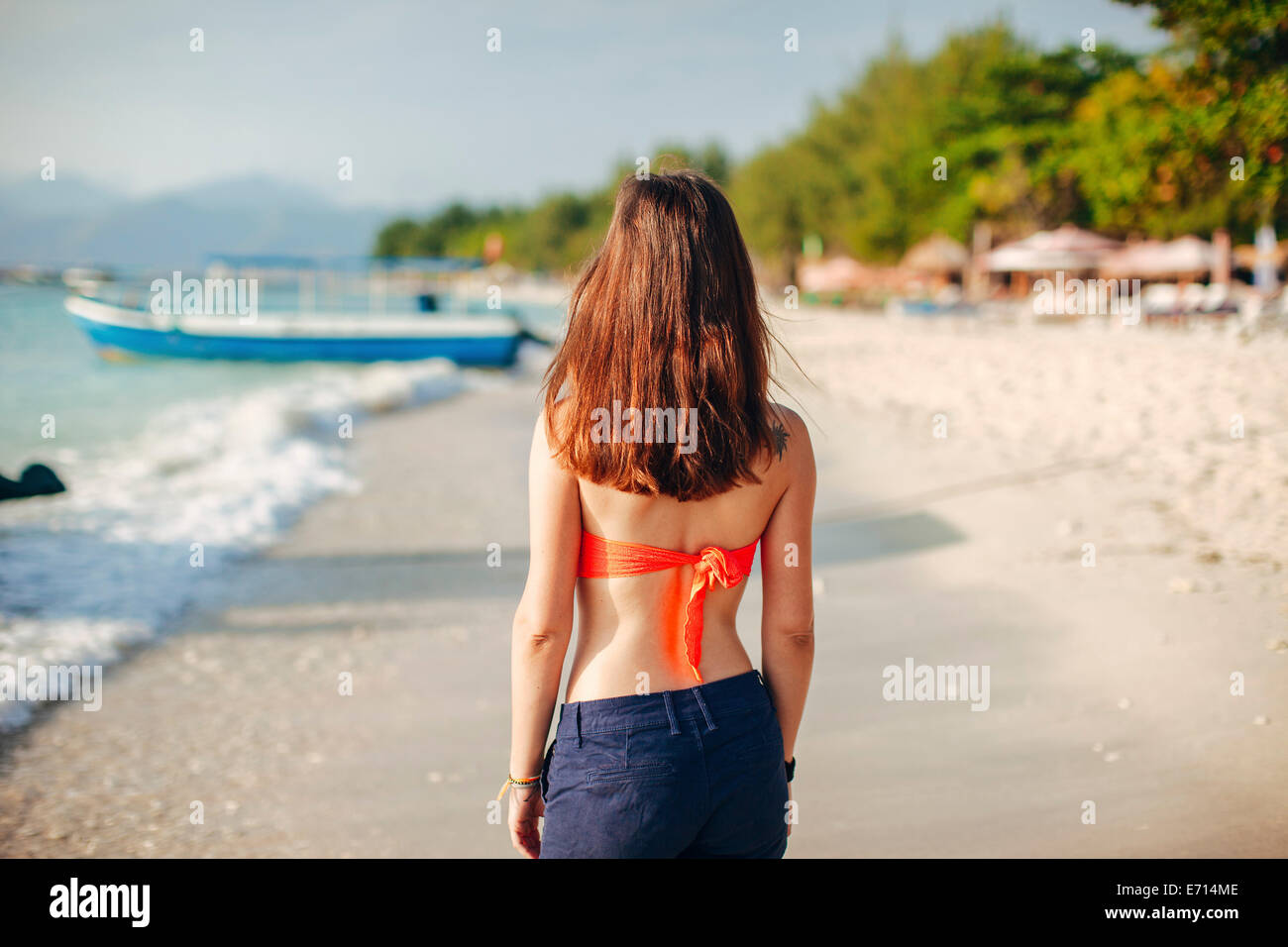 Indonesia, Gili Islands, woman standing on the beach, back view Stock Photo