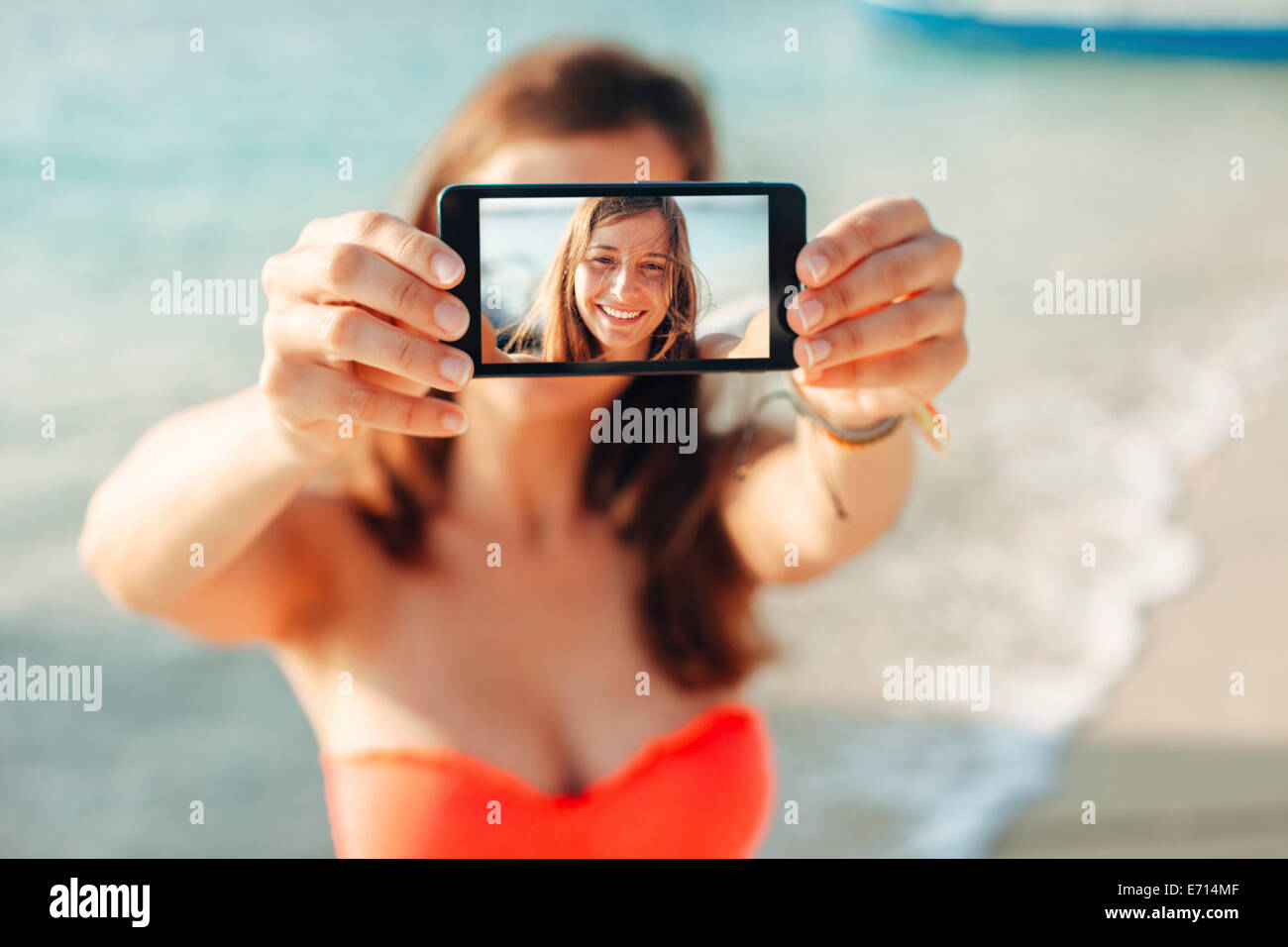 Indonesia, Gili Islands, woman on the beach showing smartphone with her selfie Stock Photo