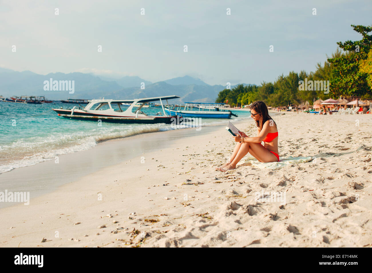 Indonesia, Gili Islands, woman reading a book on the beach Stock Photo