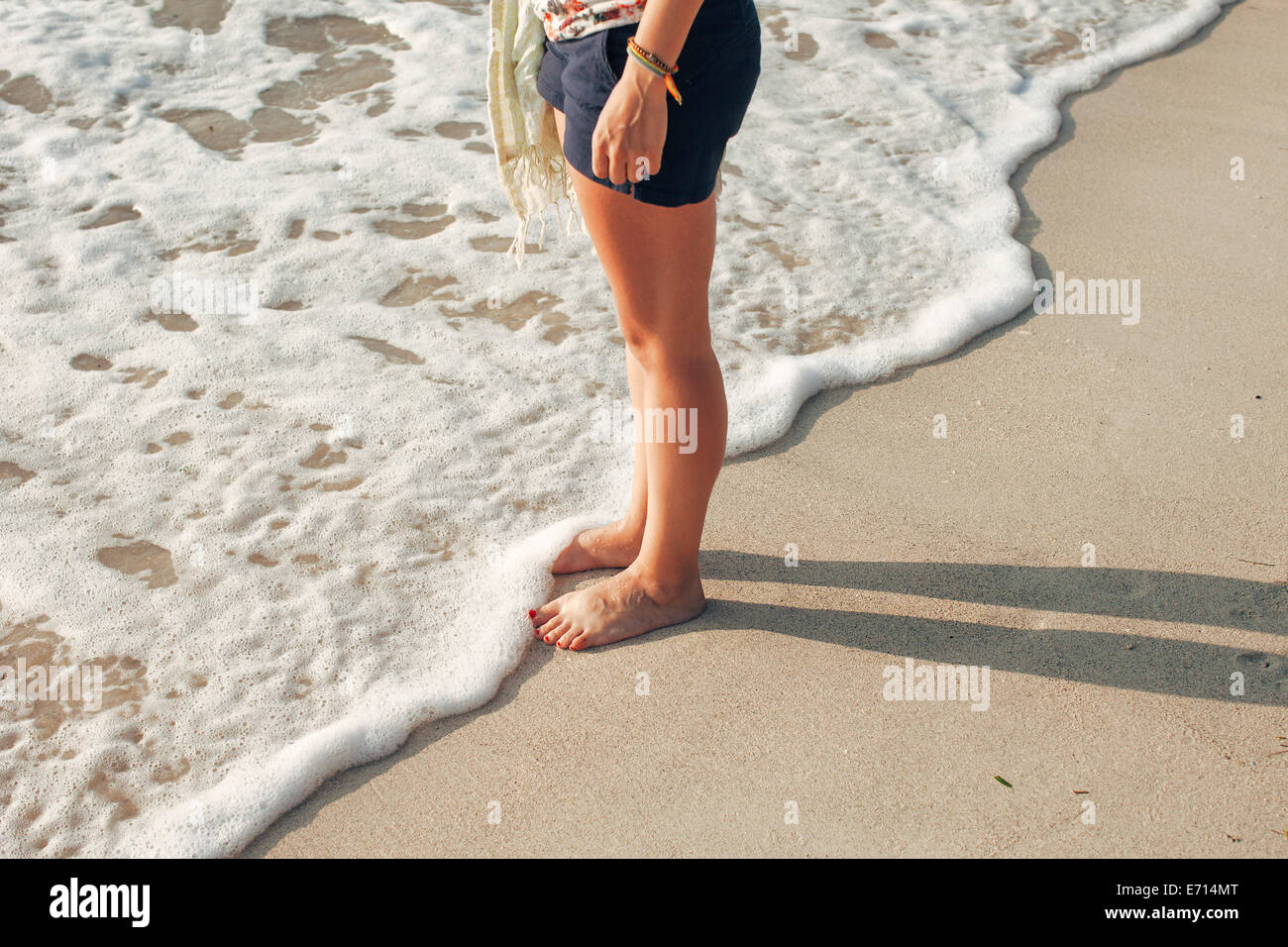 Indonesia, Gili Islands, woman standing on the beach, partial view Stock Photo