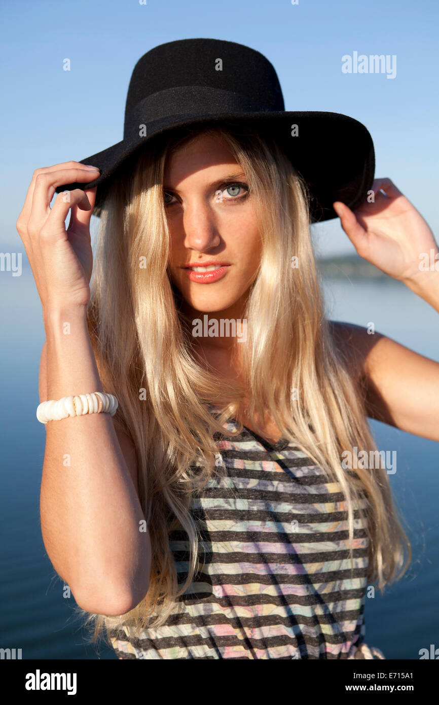 Portrait of young woman wearing black hat Stock Photo - Alamy