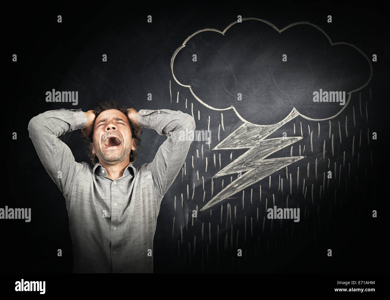 stressed man and drawing cloud with flash on blackboard Stock Photo