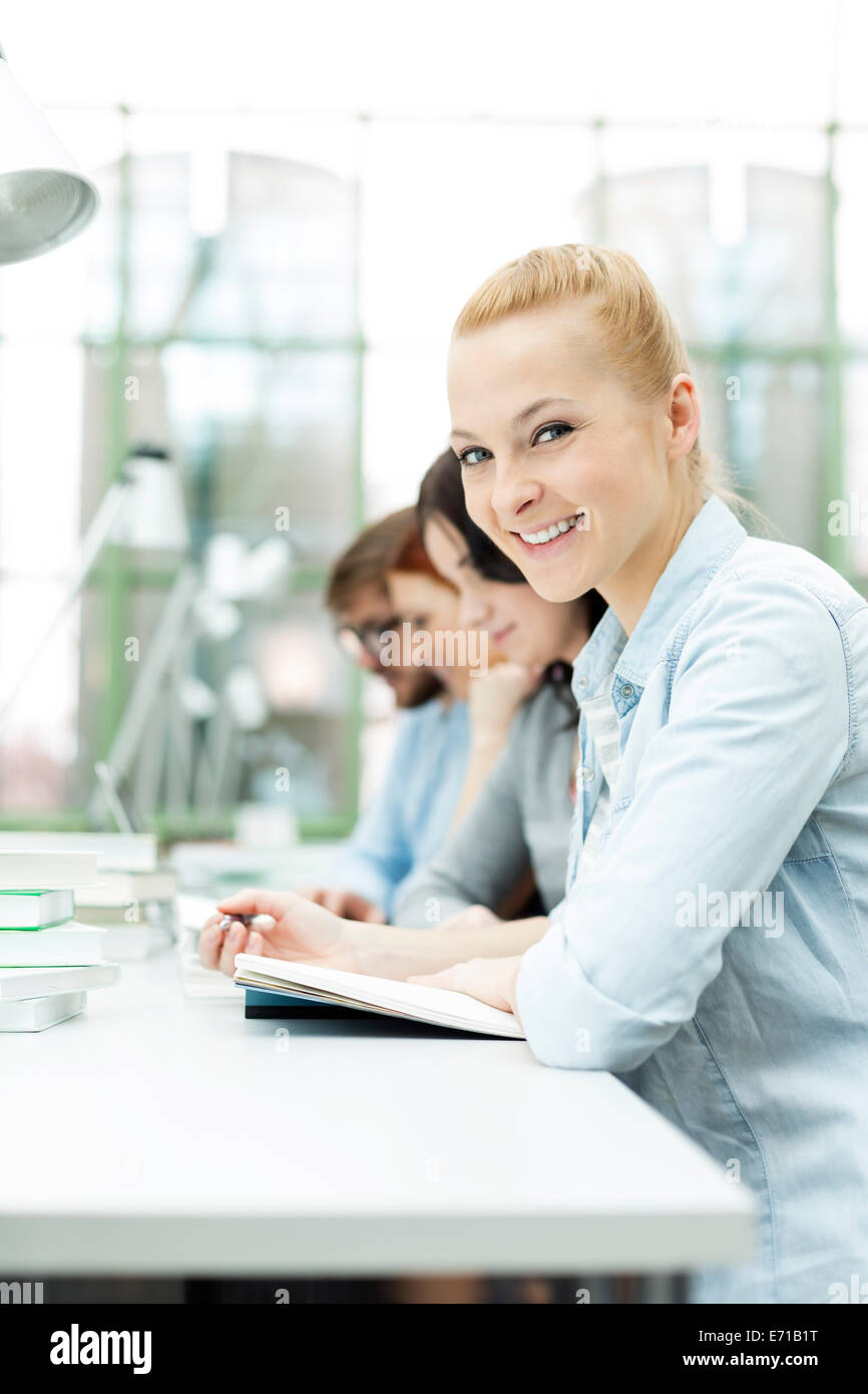 Student in a university library reading book Stock Photo - Alamy