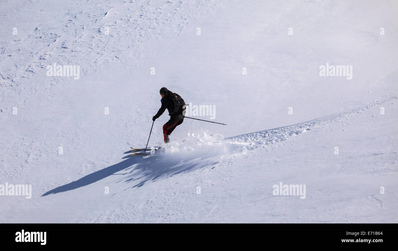 Lone touring skier skiing on fresh snow Stock Photo