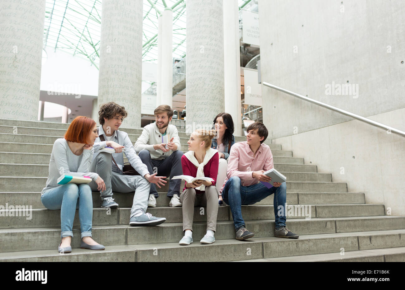 Group of students with books sitting on stairs Stock Photo - Alamy