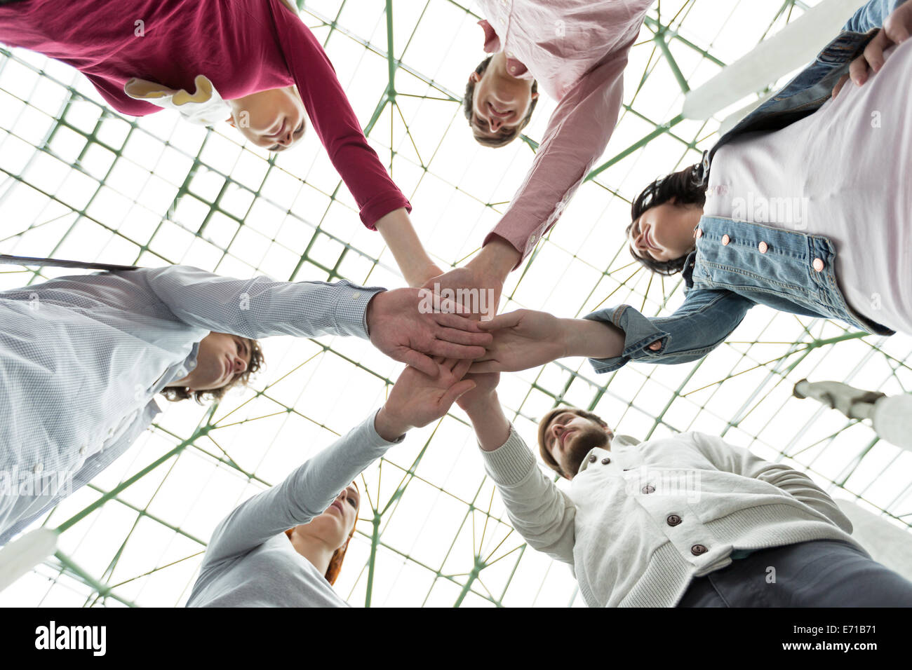 Group of young people stacking their hands Stock Photo - Alamy