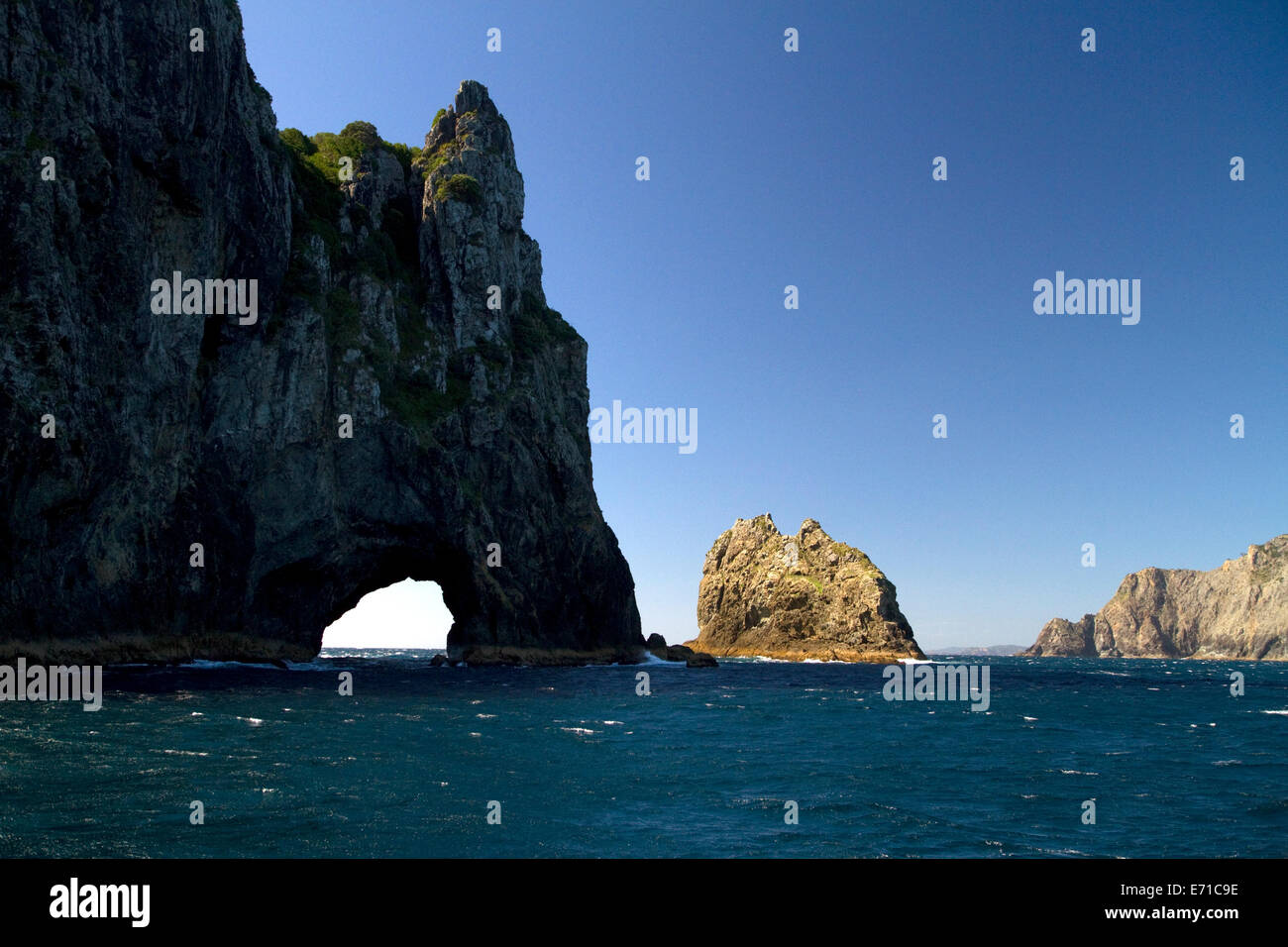 'The Hole in The Rock' located in the Bay of Islands on the northern tip of Cape Brett, North Island, New Zealand. Stock Photo