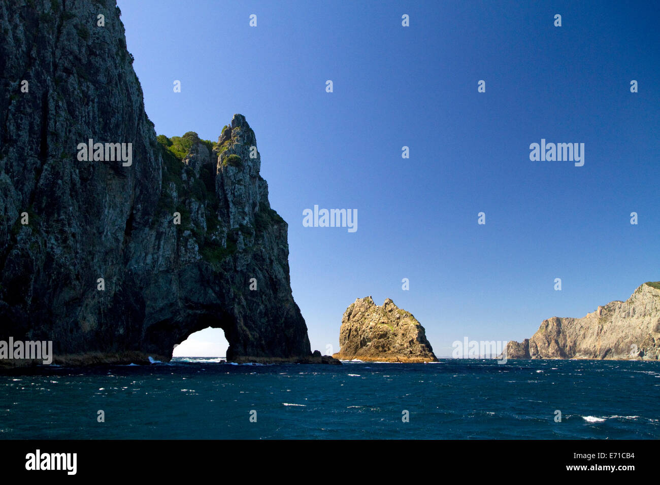 'The Hole in The Rock' located in the Bay of Islands on the northern tip of Cape Brett, North Island, New Zealand. Stock Photo