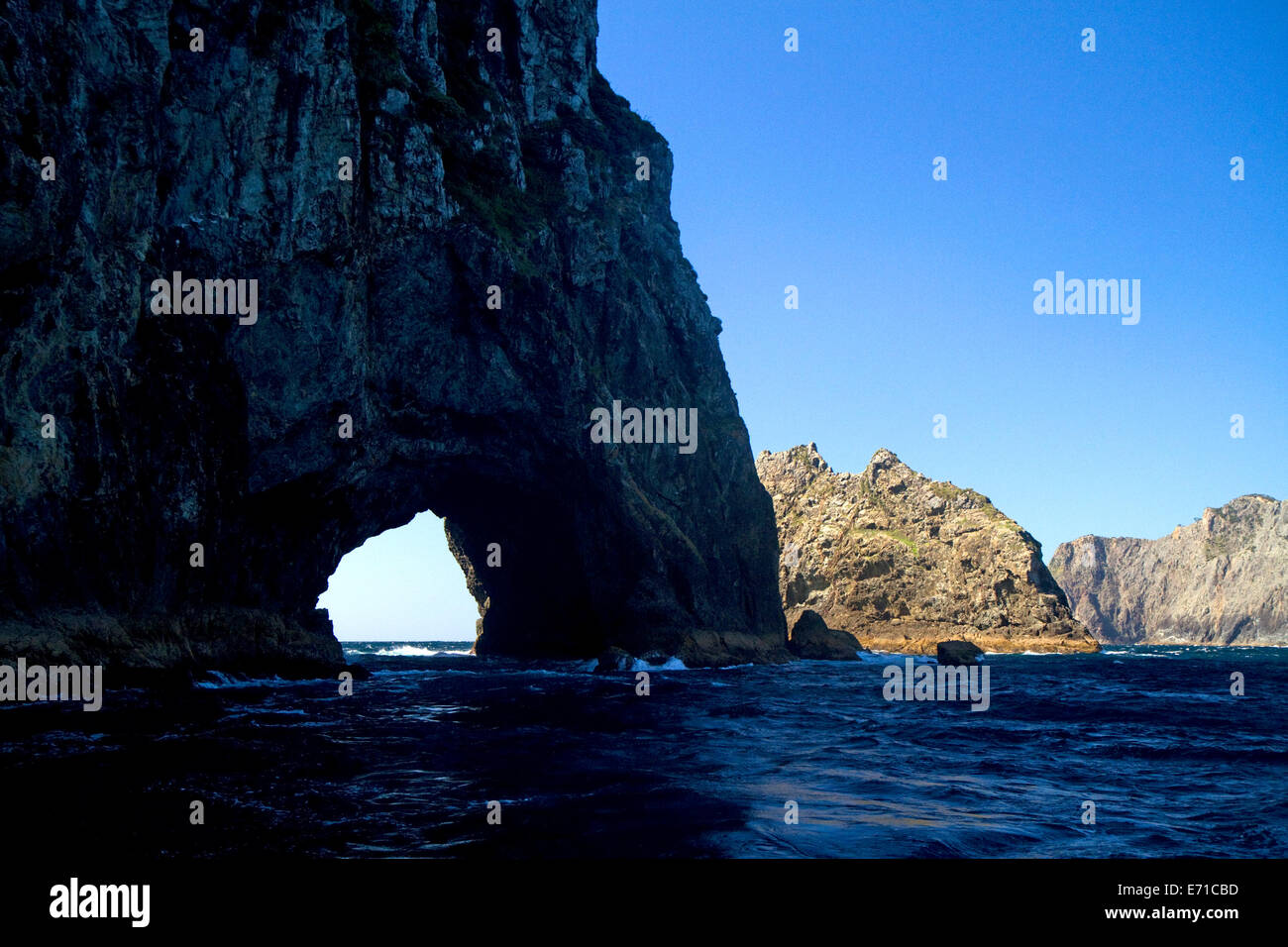 'The Hole in The Rock' located in the Bay of Islands on the northern tip of Cape Brett, North Island, New Zealand. Stock Photo
