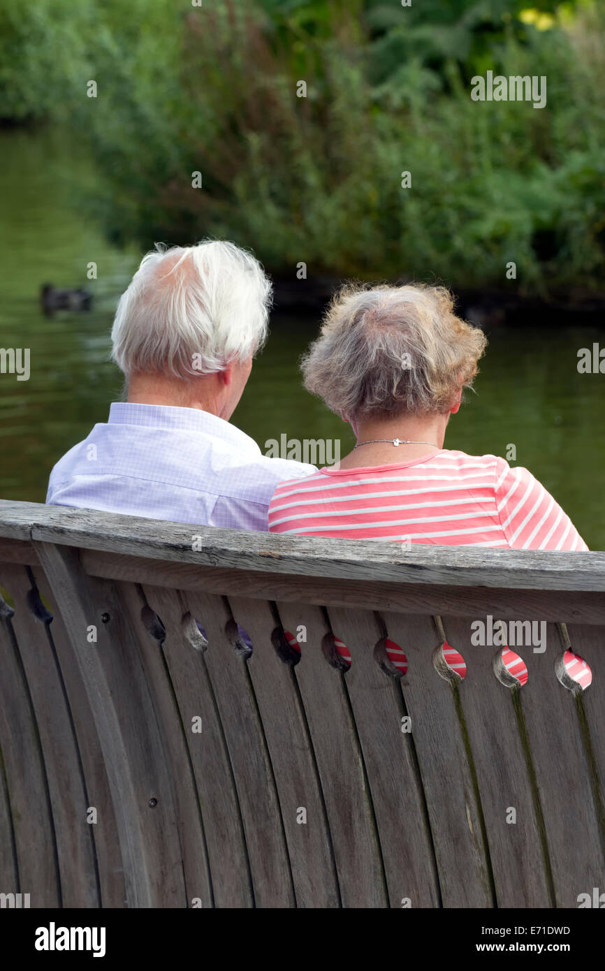 Elderly couple take a break beside lake at RHS Wisley Surrey Stock Photo