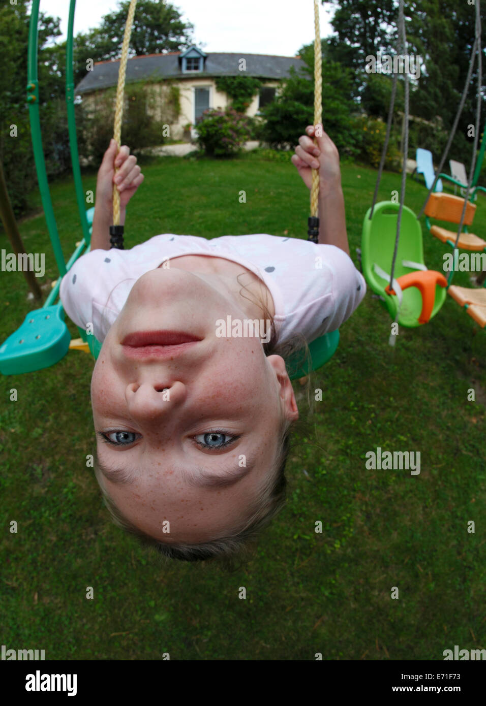 Young girl upside down on a swing Stock Photo
