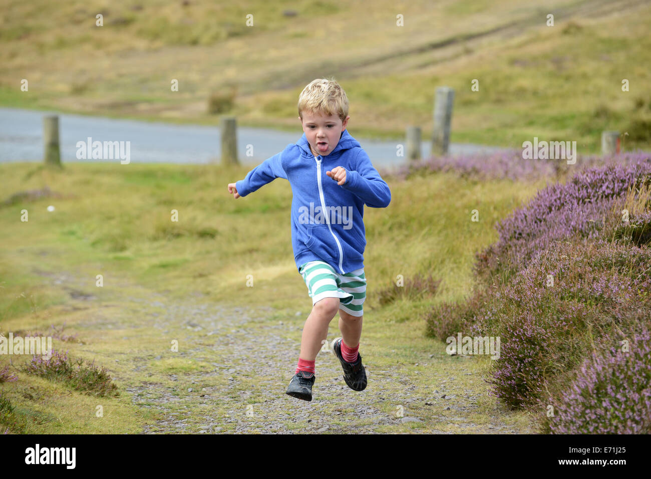 Young boy child running in countryside rural area uk Stock Photo