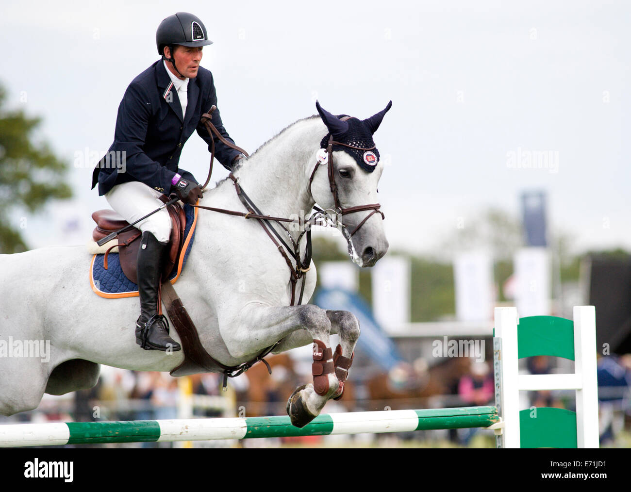 A horse and rider jump a fence in the show jumping competition at the ...