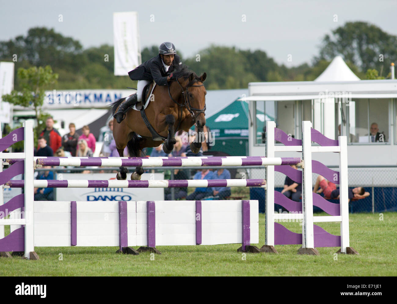 A horse and rider jump a fence in the show jumping competition at the ...