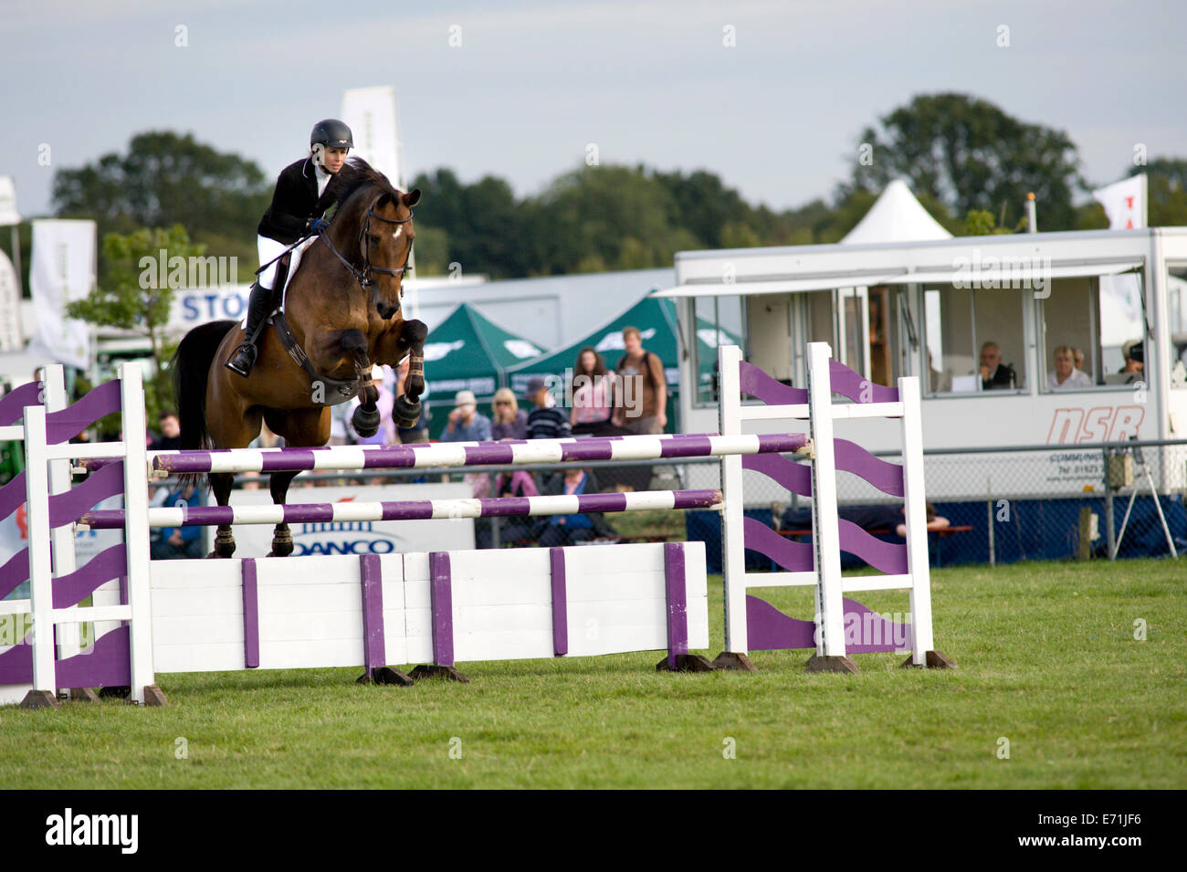 A horse and rider over a fence in the show jumping competition at the ...