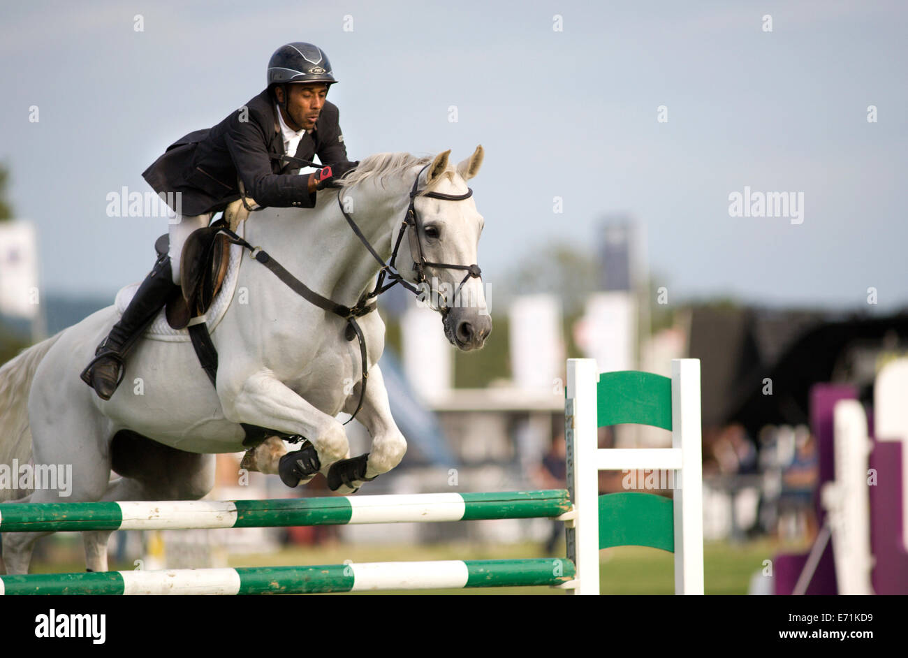 A horse and rider jump a fence in the show jumping competition at the ...