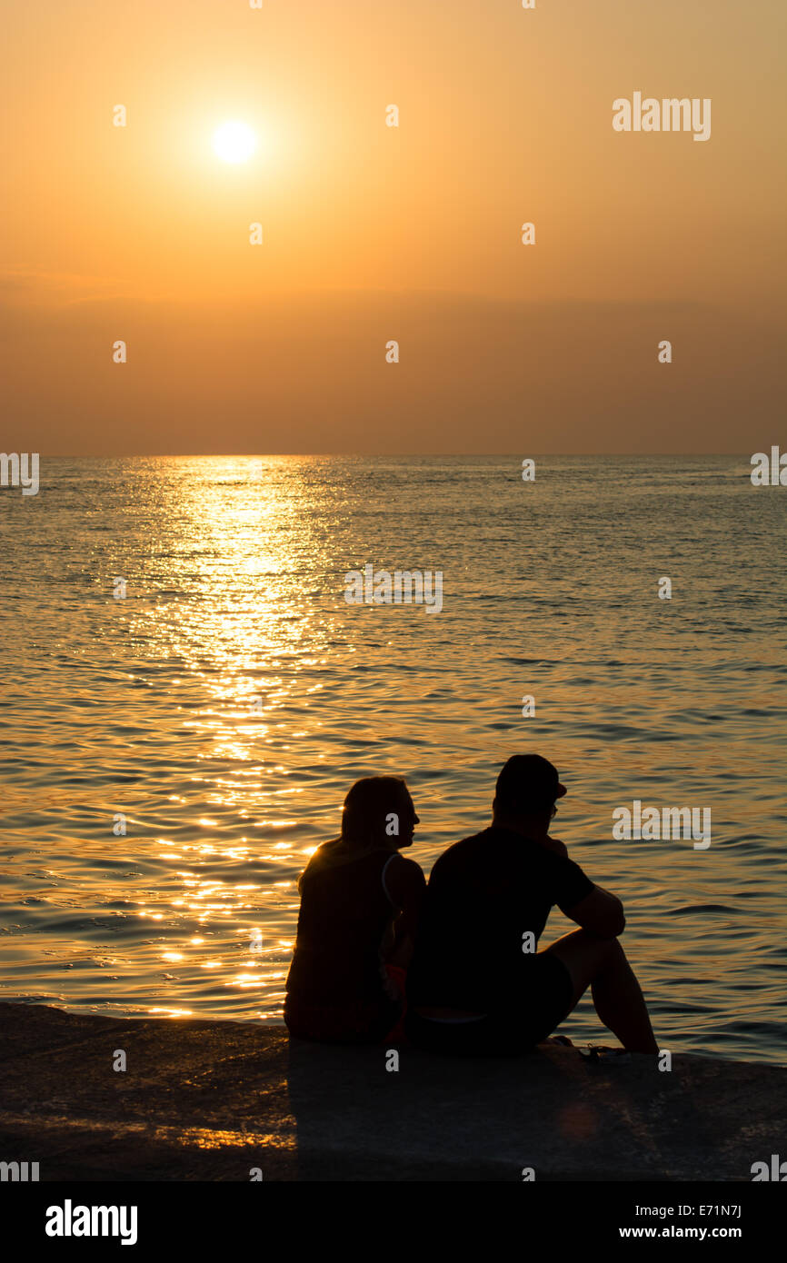 Young Couple On Beach At Sunset Stock Photo