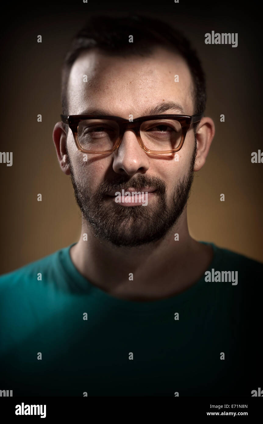 Young hipster guy wearing retro glasses. Dramatic light Stock Photo