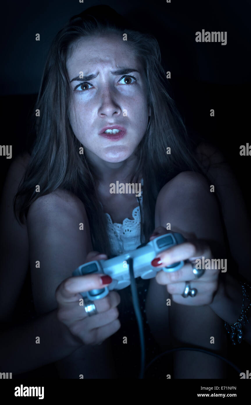 Teenage girl playing video games, holding joy pad, looking very frustrated. Stock Photo