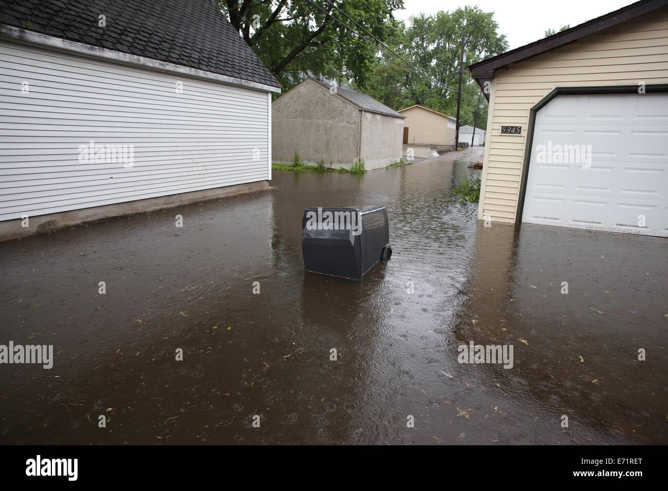 An overturned garbage bin in a flooded alley in Minneapolis, Minnesota. Stock Photo