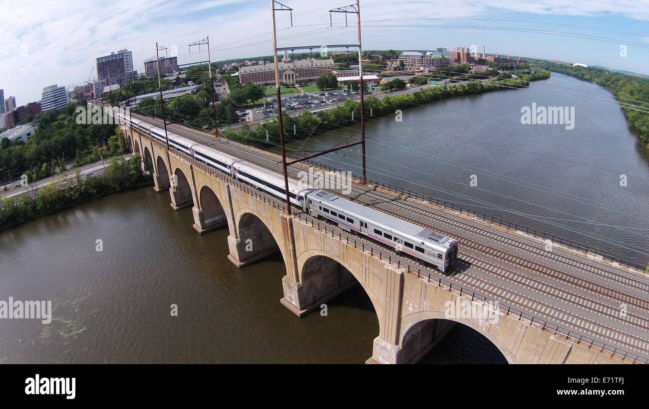 Aerial image of a train crossing the Northeast Corridor Railroad Bridge over the Raritan River in New Brunswick, New Jersey Stock Photo