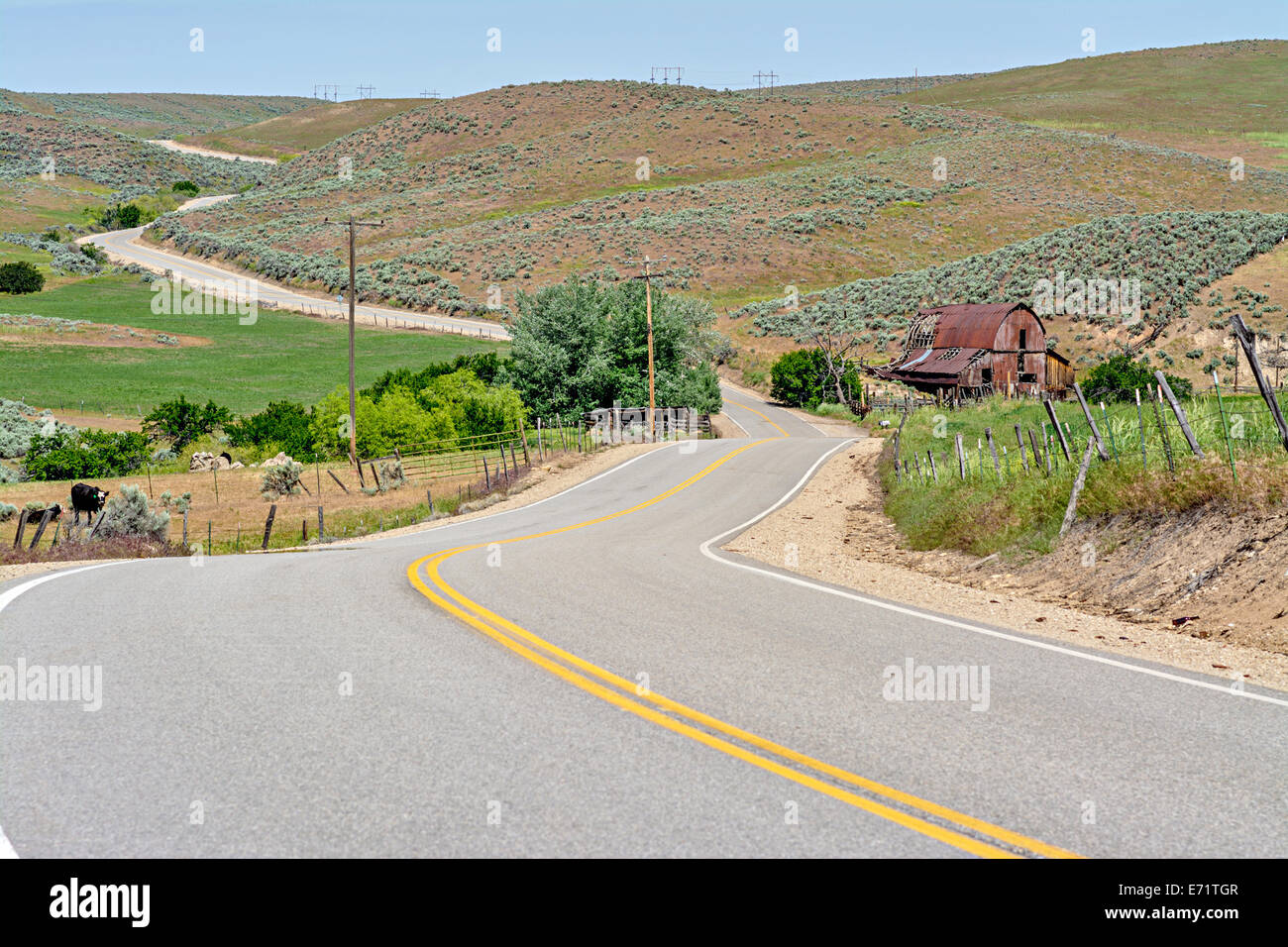 Red rusty barn and country road winds through hills Stock Photo - Alamy