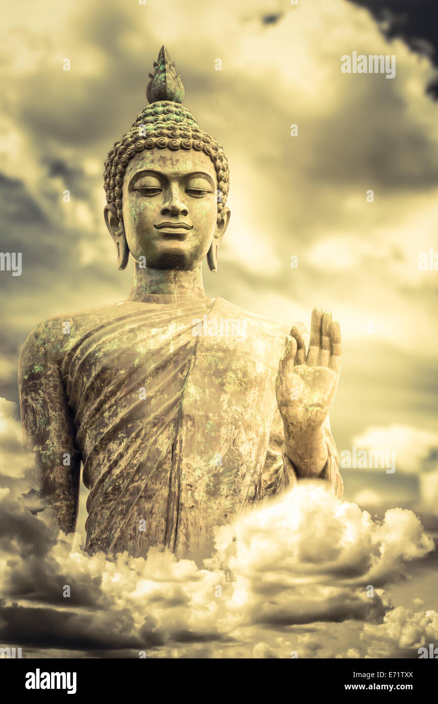 The statue of Big Buddha face with hand in Thailand on storm clouds background Stock Photo