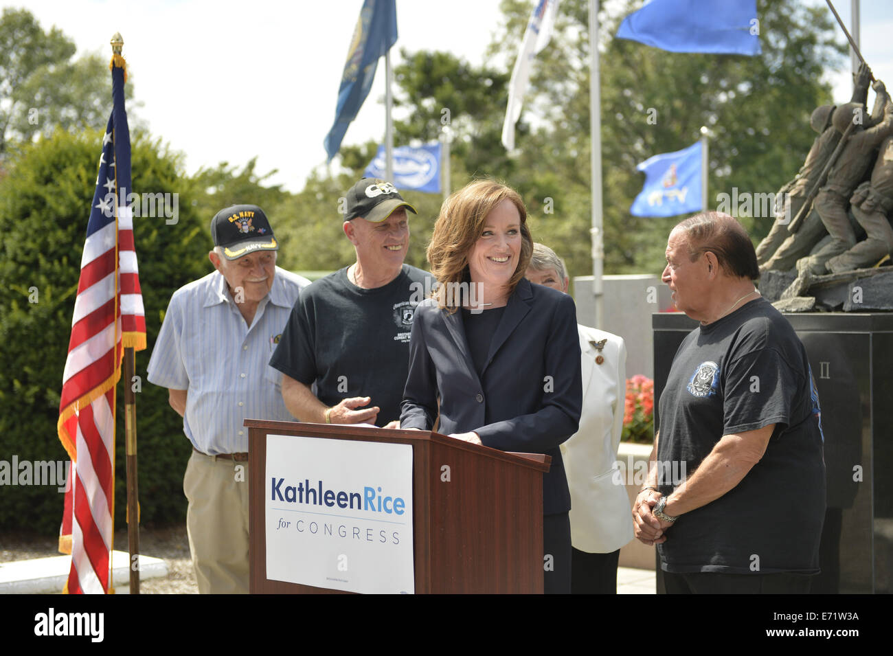 East Meadow, New York, USA. 3rd Sep, 2014. KATHLEEN RICE, at podium, Democratic congressional candidate (NY-04), releases a whitepaper on veterans policy and announces formation of her campaign's Veterans Advisory Committee, at Veterans Memorial at Eisenhower Park, after touring Northport VA Medical Center with outgoing Rep. CAROLYN MCCARTHY (behind Rice, in white jacket). Congresswoman McCarthy and several committee members joined Rice at the press conference, including: PAUL ZYDOR, (in blue shirt) of Merrick, U.S. Navy, Korean War Veteran; PAT YNGSTROM, (in black T-shirt and cap) of Merric Stock Photo