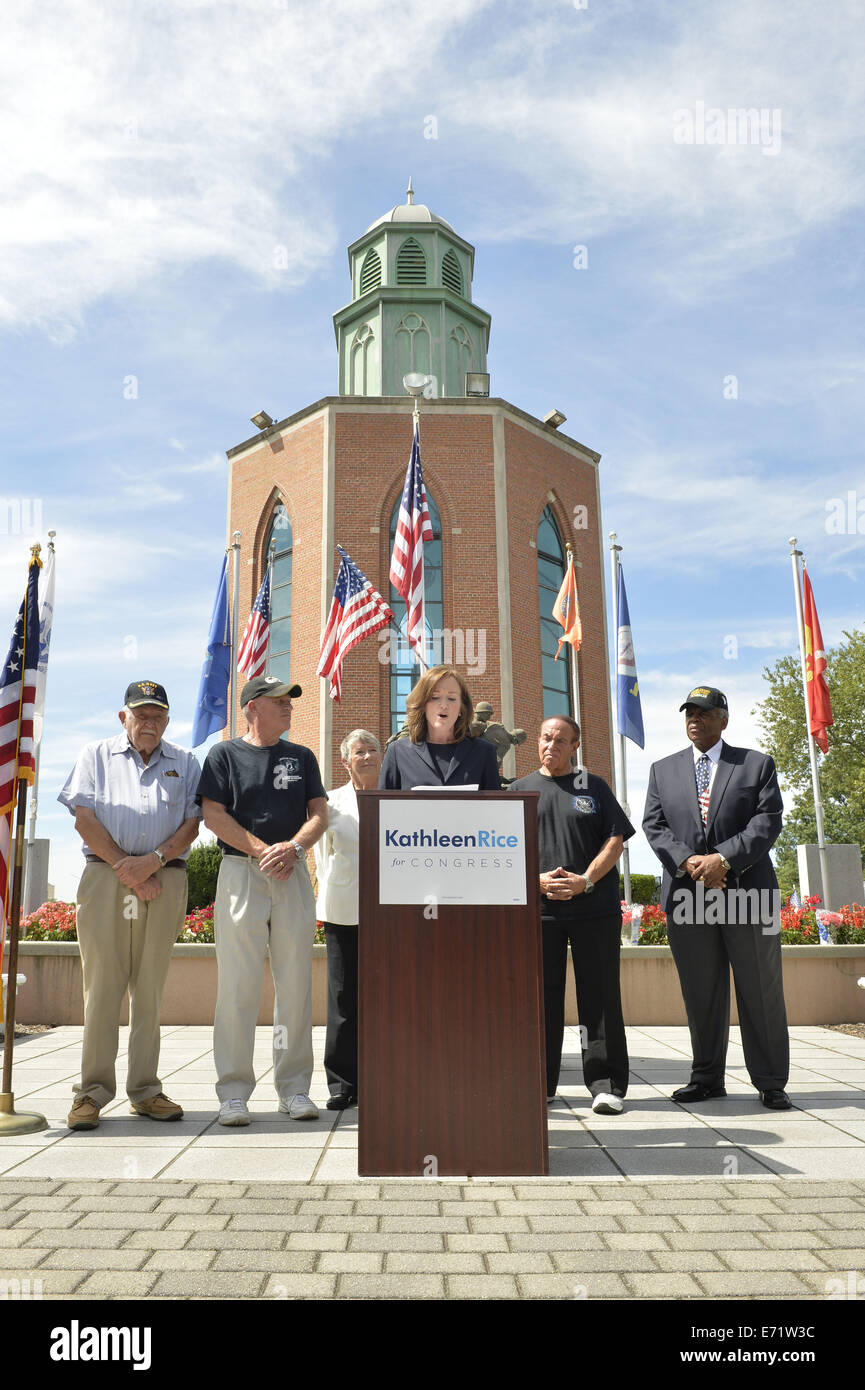 East Meadow, New York, USA. 3rd Sep, 2014. KATHLEEN RICE, at podium, Democratic congressional candidate (NY-04), releases a whitepaper on veterans policy and announces formation of her campaign's Veterans Advisory Committee, at Veterans Memorial at Eisenhower Park, after touring Northport VA Medical Center with outgoing Rep. CAROLYN MCCARTHY (in white jacket). Congresswoman McCarthy and 4 committee members joined Rice at the press conference: PAUL ZYDOR, (in blue shirt) of Merrick, U.S. Navy, Korean War Veteran; PAT YNGSTROM, (in black T-shirt and cap) of Merrick, U.S. Army Paratrooper, Viet Stock Photo