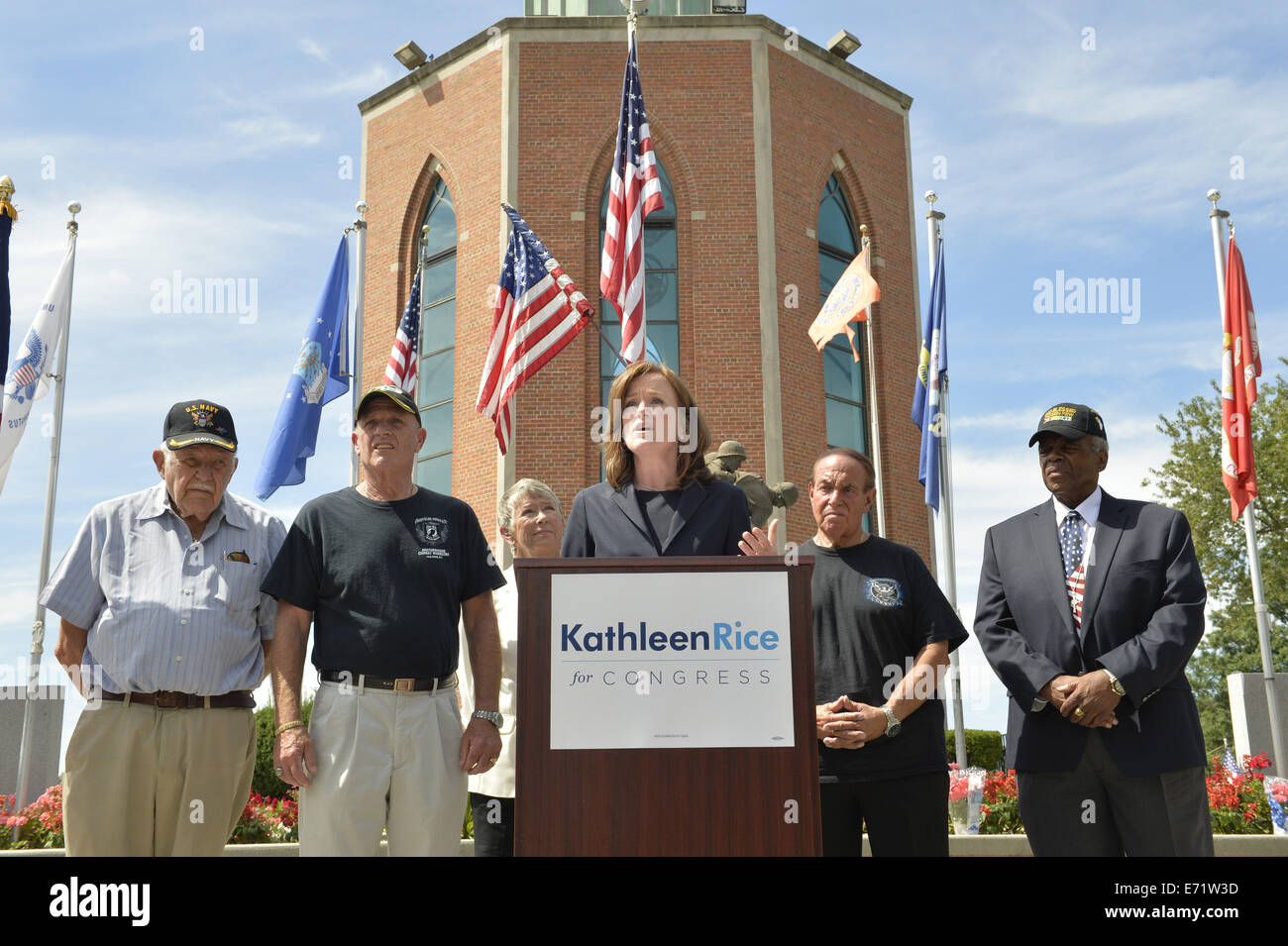 East Meadow, New York, USA. 3rd Sep, 2014. KATHLEEN RICE, at podium, Democratic congressional candidate (NY-04), releases a whitepaper on veterans policy and announces formation of her campaign's Veterans Advisory Committee, at Veterans Memorial at Eisenhower Park, after touring Northport VA Medical Center with outgoing Rep. CAROLYN MCCARTHY (in white jacket). Congresswoman McCarthy and 4 committee members joined Rice at the press conference: PAUL ZYDOR, (in blue shirt) of Merrick, U.S. Navy, Korean War Veteran; PAT YNGSTROM, (in black T-shirt and cap) of Merrick, U.S. Army Paratrooper, Viet Stock Photo