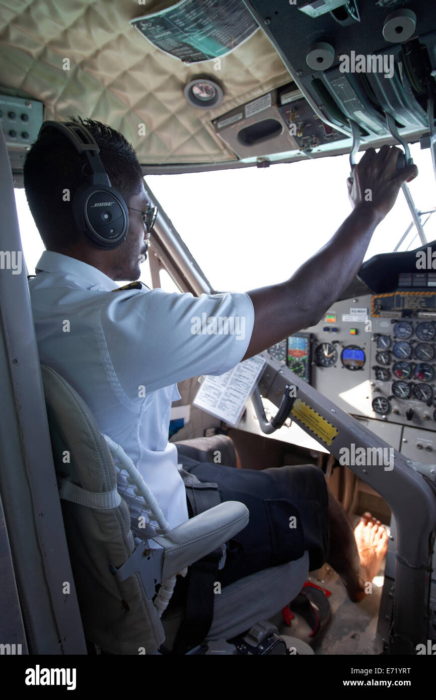 Pilot during the start in the cockpit of a hydroplane, barefoot, De Havilland Canada DHC-6 Twin Otter, Maldives Stock Photo