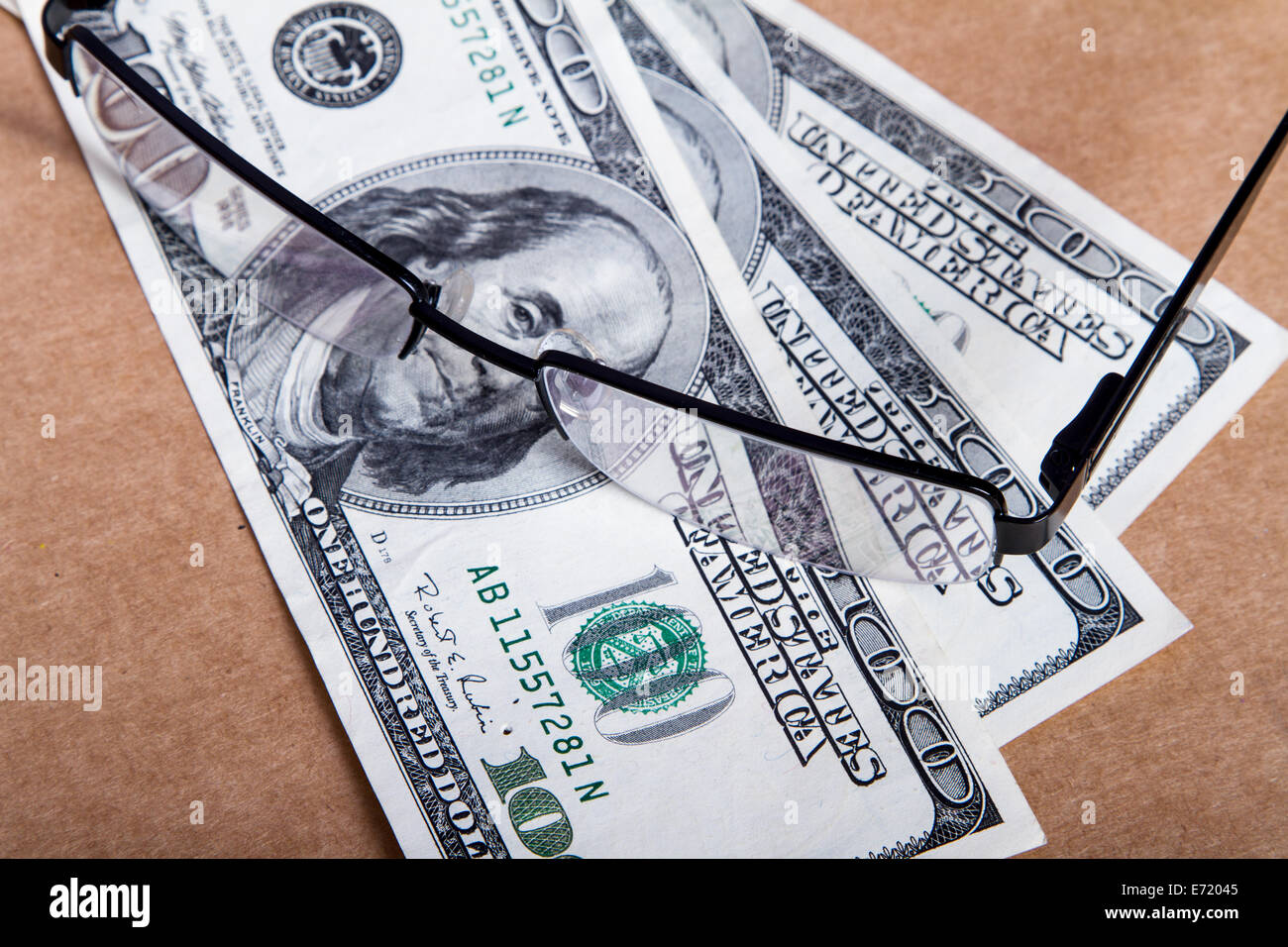 Pair of eyeglasses on one hundred dollar banknotes. Stock Photo