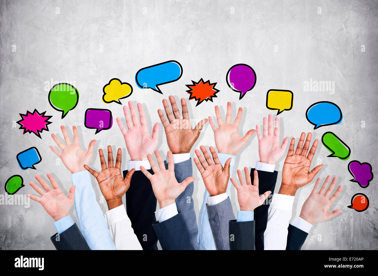 Business people's arms raised with speech bubble by concrete wall. Stock Photo