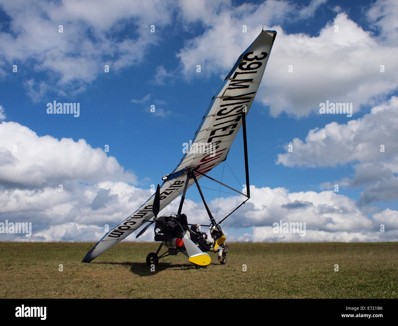 Ultralight aeroplane in blue sky with clouds, passenger waving, Jura, France Stock Photo