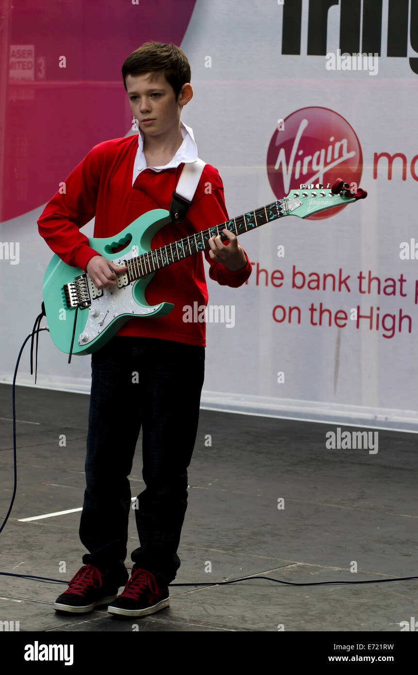 Young boy with electric guitar busking at the annual Festival Fringe in