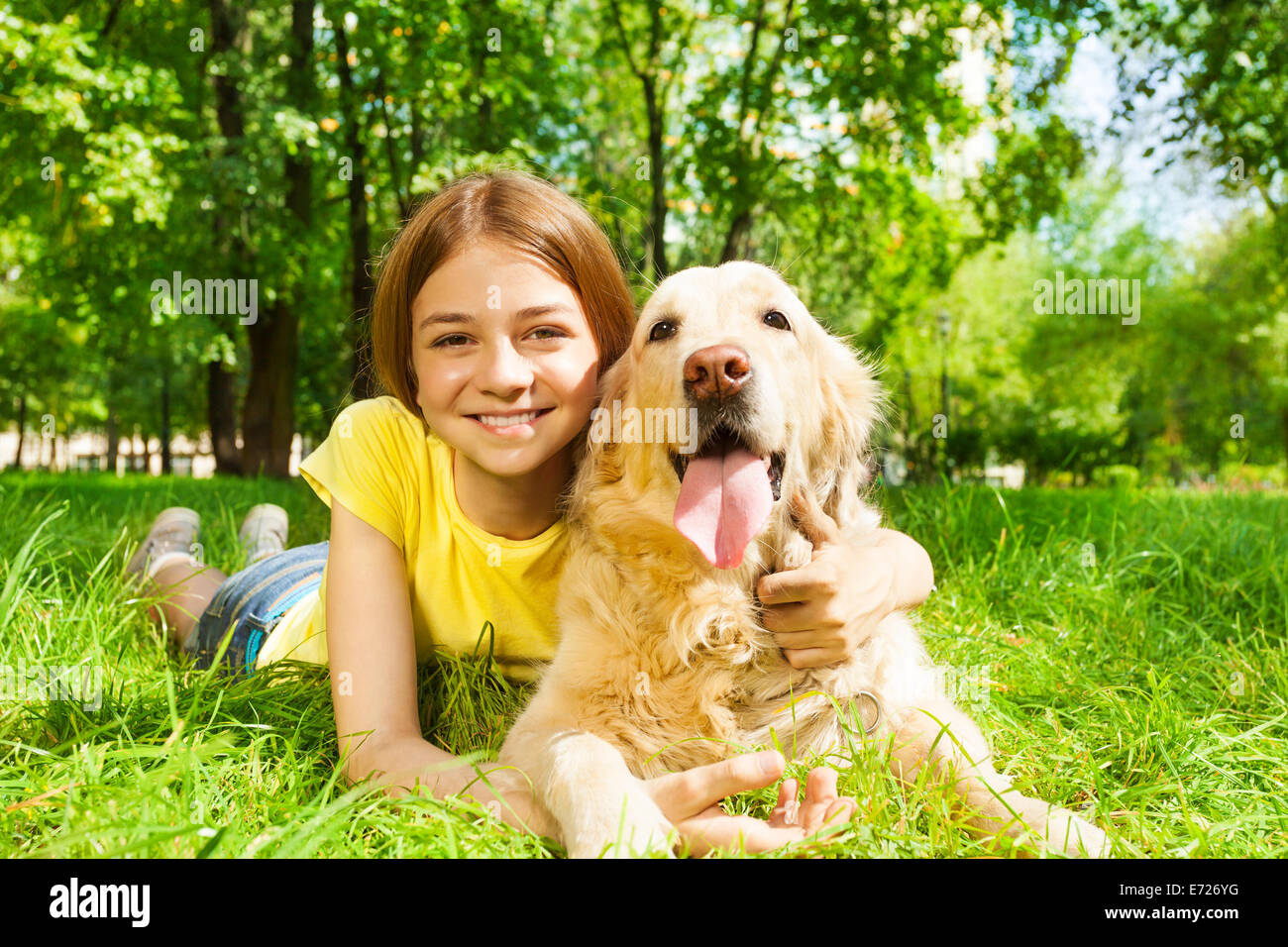 Teenage girl laying with her pet dog in park Stock Photo - Alamy