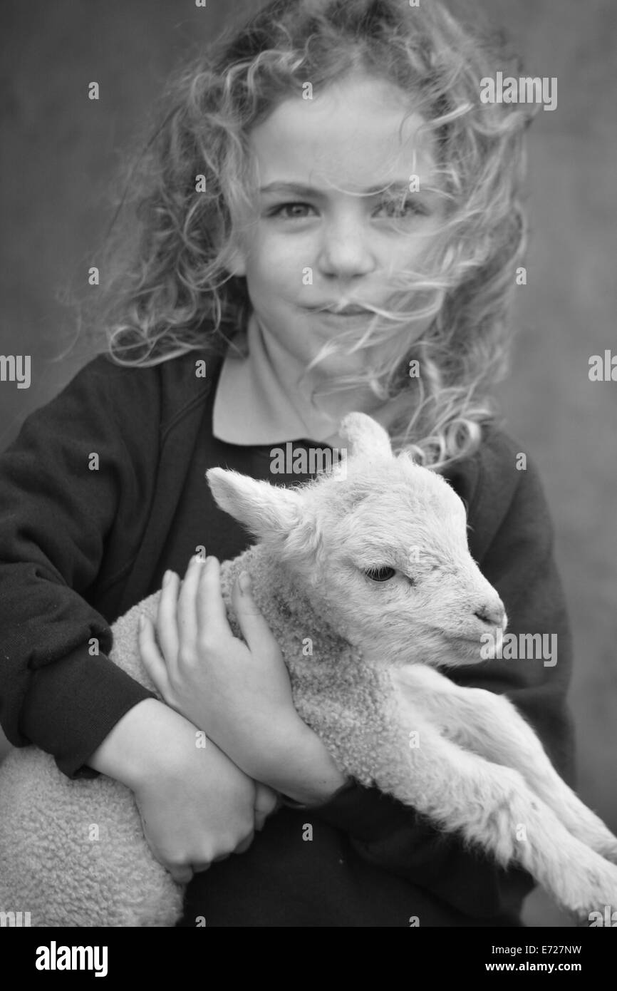 Young girl holding a spring lamb Stock Photo