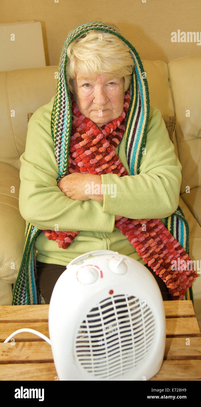 Old lady trying to keep warm in a cold winter Stock Photo