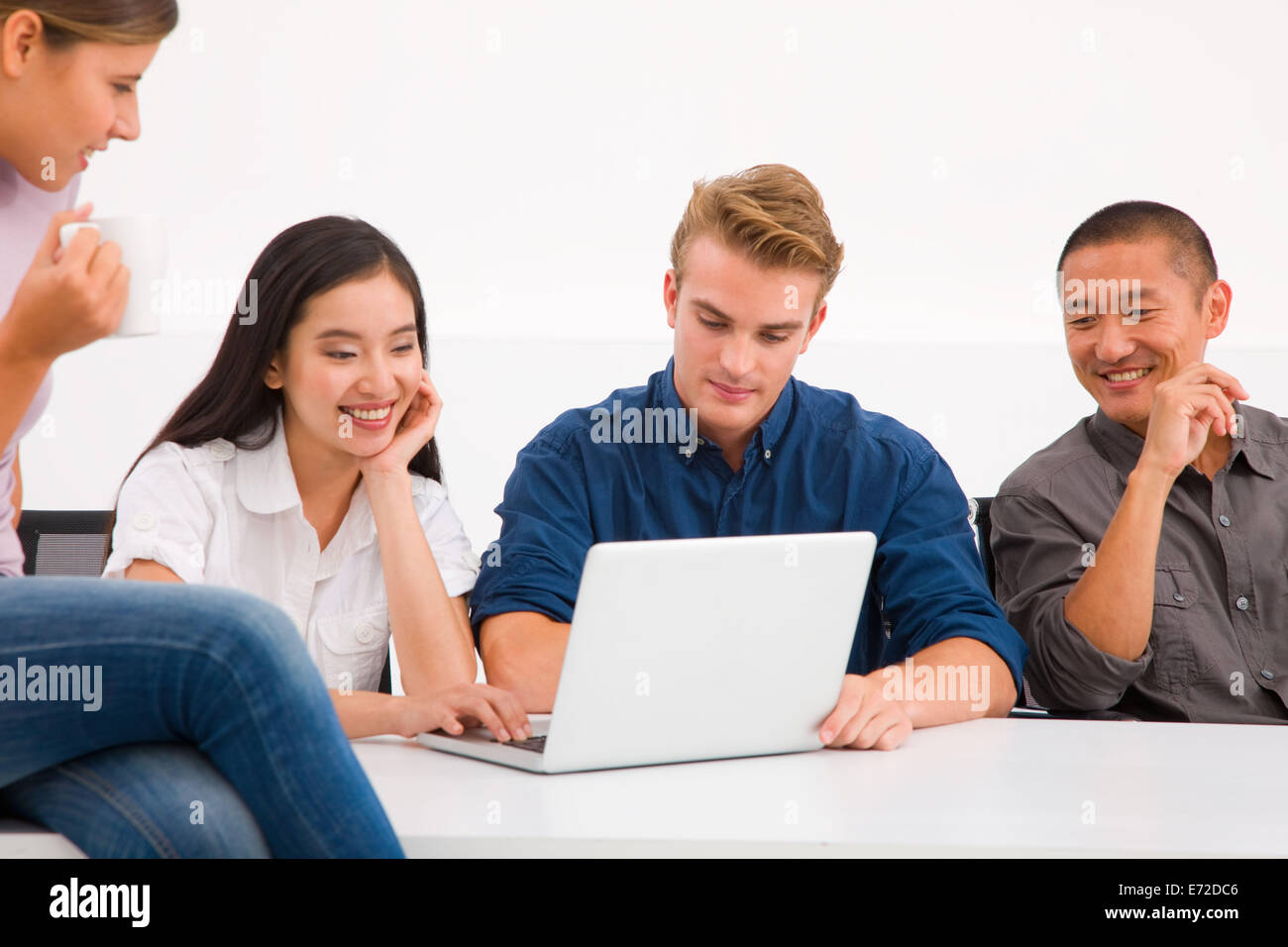 Multi ethnic group of executives looking laptop Stock Photo