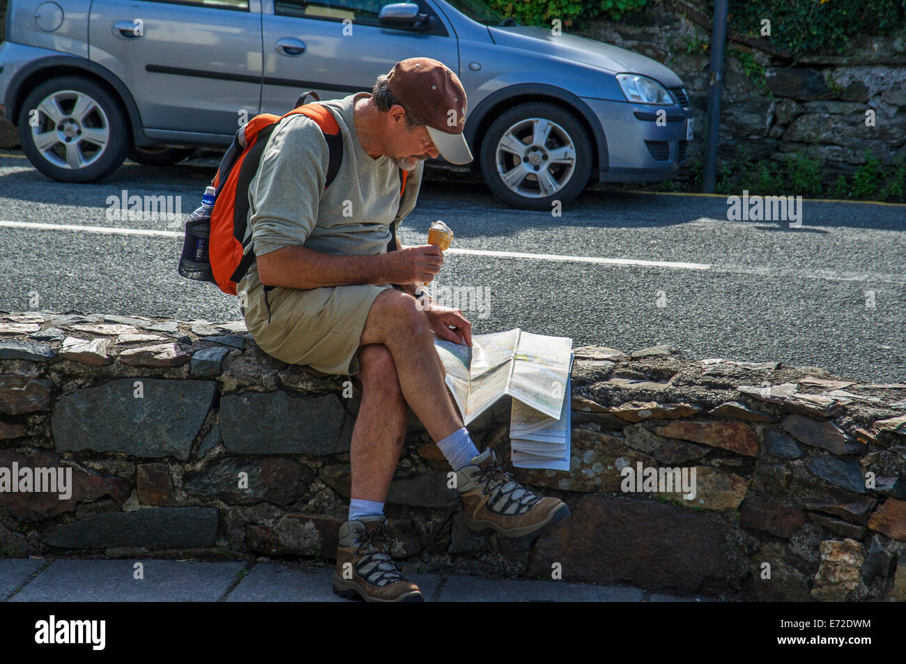 Hiker checking route on map and enjoying an icecream, Snowdonia National Park, North Wales Stock Photo